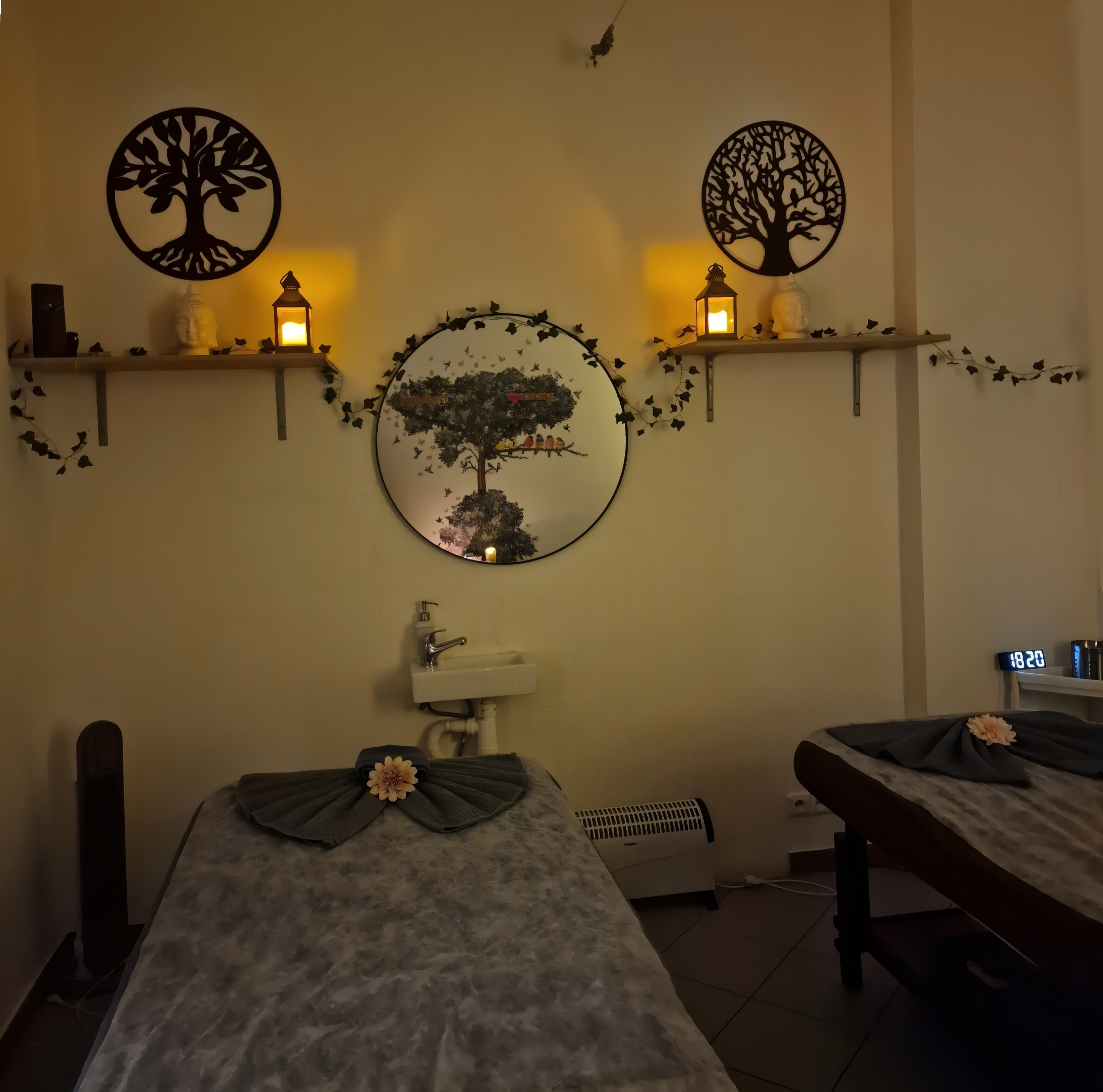 Masážní místnost s teplým osvětlením a dekoracemi stromů života